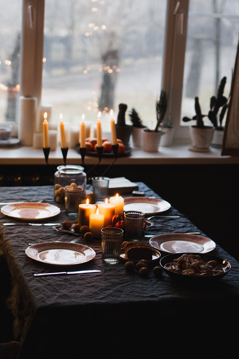 Warm candlelit home dinner table set for a dinner party